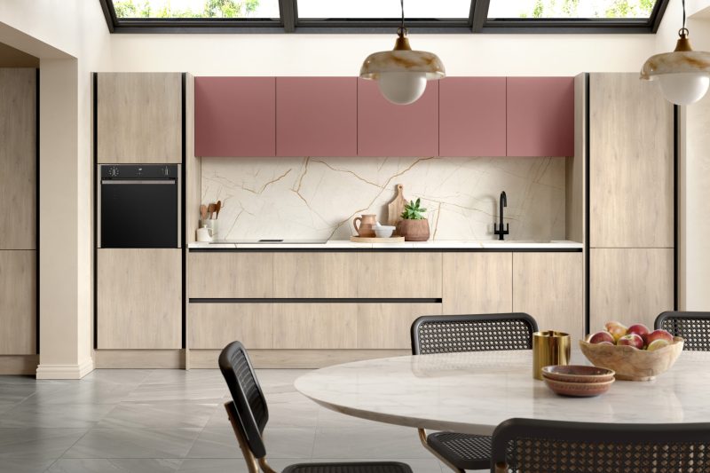 Bold, layered modern kitchen pairing Cremona oak with rusty red supermatt inrail doors
